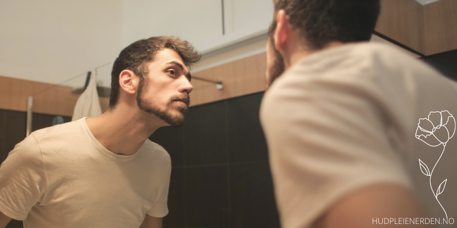 ung mann som ser seg i speilet